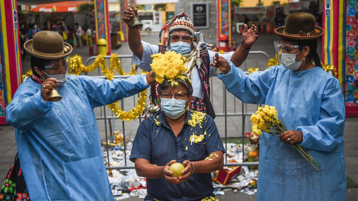 Shamans performs a flower ritual to a man during a ritual of predictions at the Wishes Market in Lima. Every year before New Year, shamans from the Andean region make predictions for the next year at this market in the Peruvian capital. Credit: AFP