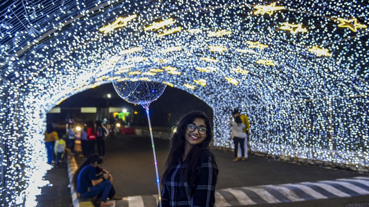 People outside an illuminated mall on the eve of the New Year in Mumbai. Credit: PTI