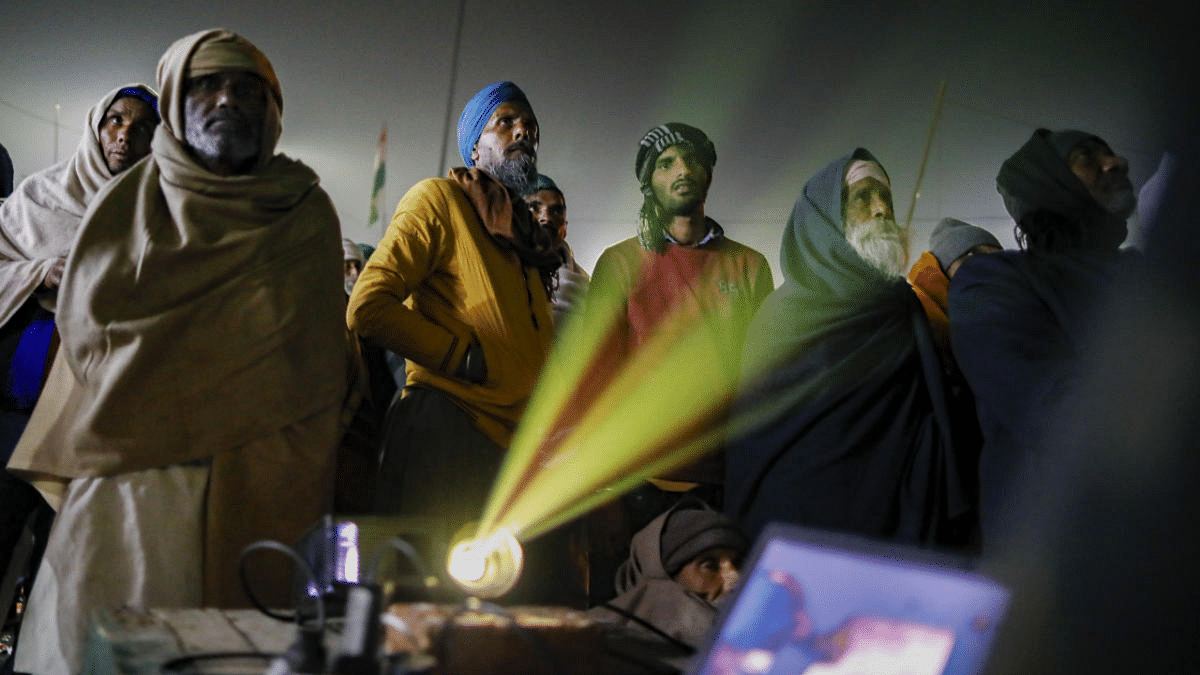 Farmers watch a movie projected on a screen at their agitation site at Ghazipur border, in New Delhi, Thursday, Dec. 31, 2020. Thousands of farmers are protesting against the Centre's farm laws at Delhi borders. Credit: PTI