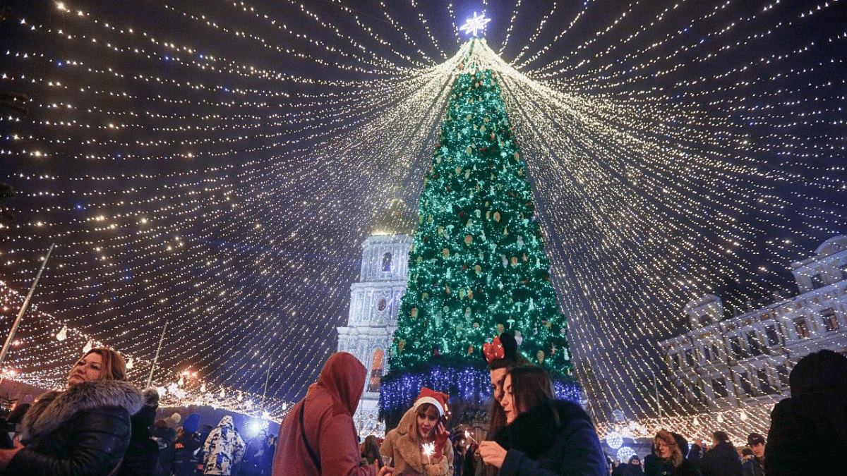 People celebrate the New Year under the lights of the Christmas tree in Kyiv, Ukraine. Credit: AP/PTI