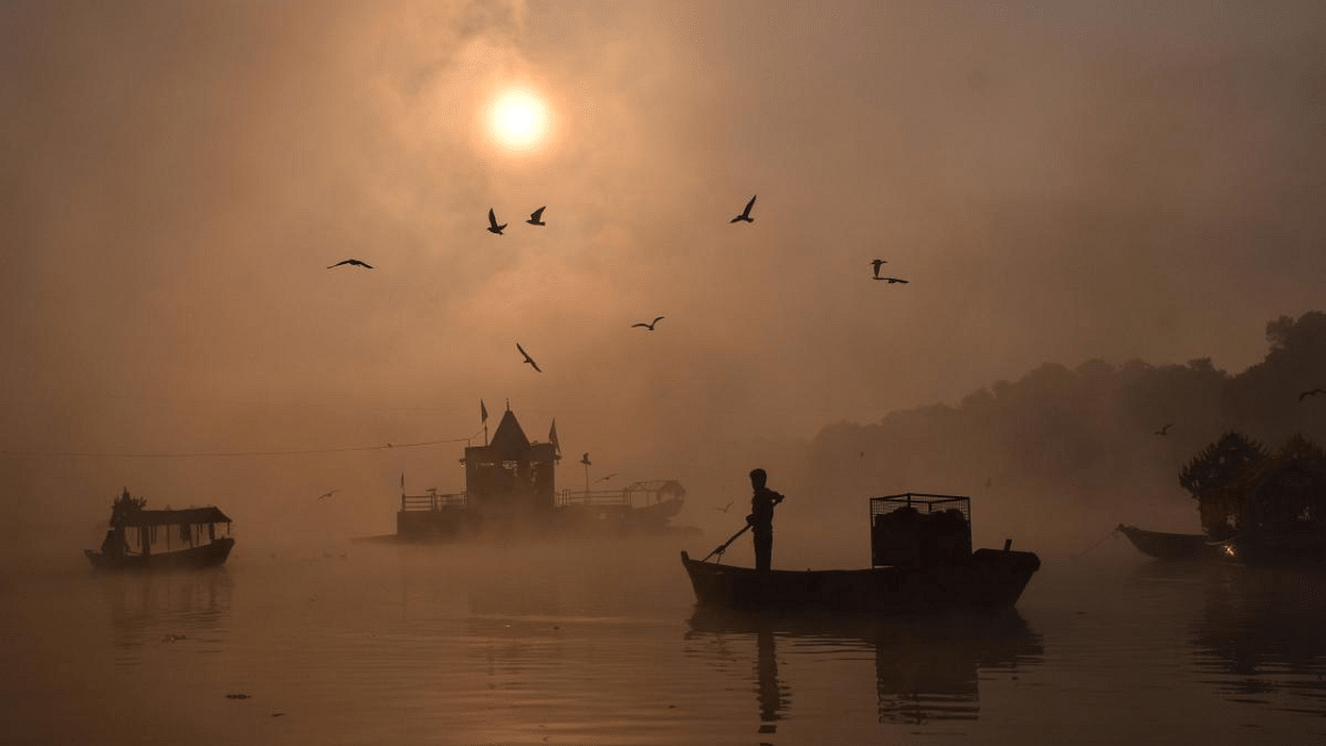A man rows his boat amid dense fog to cross the Narmada river during a cold winter morning, at Gwarighat, about 15 km from Jabalpur. Credit: AFP