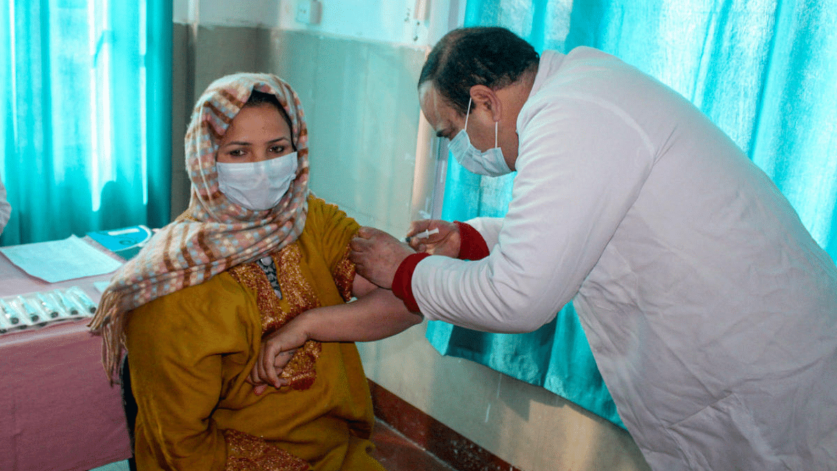 A medic demonstrates the administration of Covaxin on a health worker during a dry run in Srinagar. Credit: PTI Photo