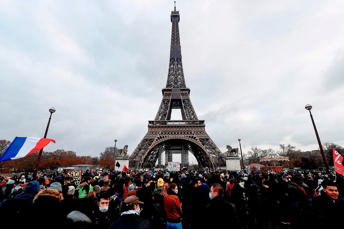 People take part in a white march in memory of Cedric Chouviat, near the Eiffel Tower, in Paris. Credit: AFP Photo