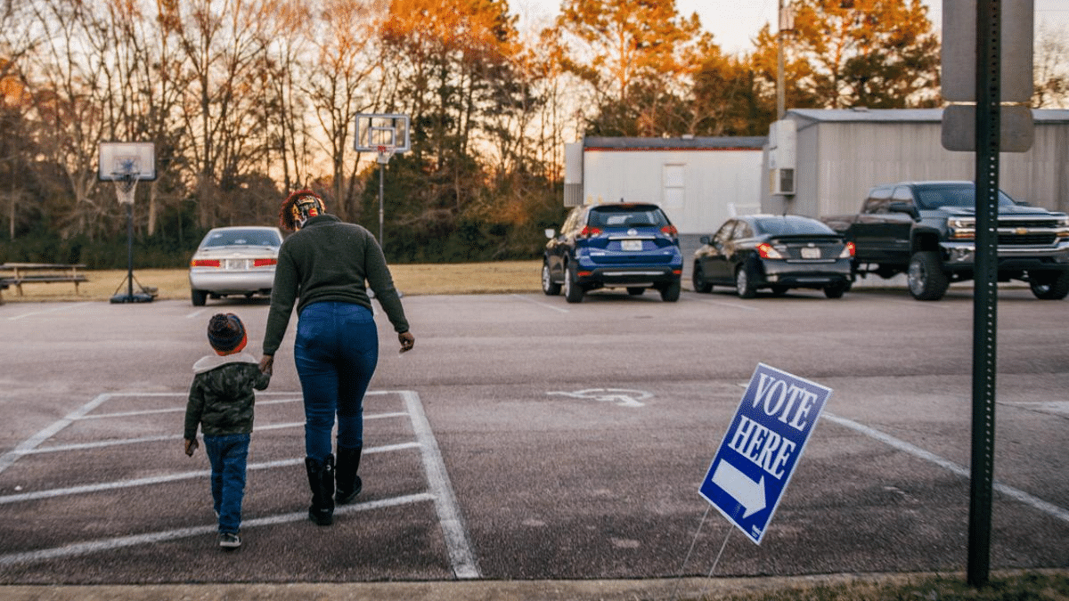 Shatevia Culpepper and her son Micah Smith exit a polling station in LaGrange, Georgia. Credit: AFP Photo