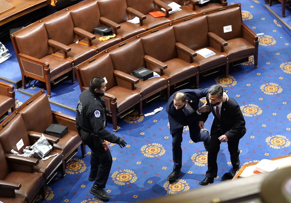 Members of congress run for cover as protesters try to enter the House Chamber during a joint session of Congress. Credit: AFP Photo