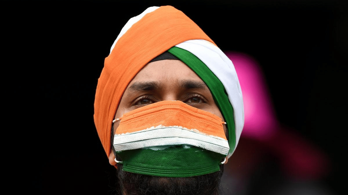 An Indian spectator in a face mask listens to the team's national anthems during the day one of the third cricket Test match at the Sydney Cricket Ground (SCG) between Australia and India. Credit: AFP Photo