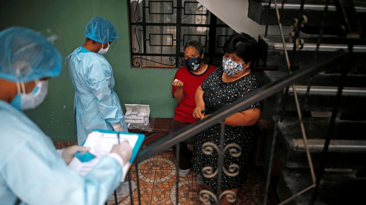 Medical workers take samples during mass testing for Covid-19 in Lima, Peru. Credit: Reuters Photo