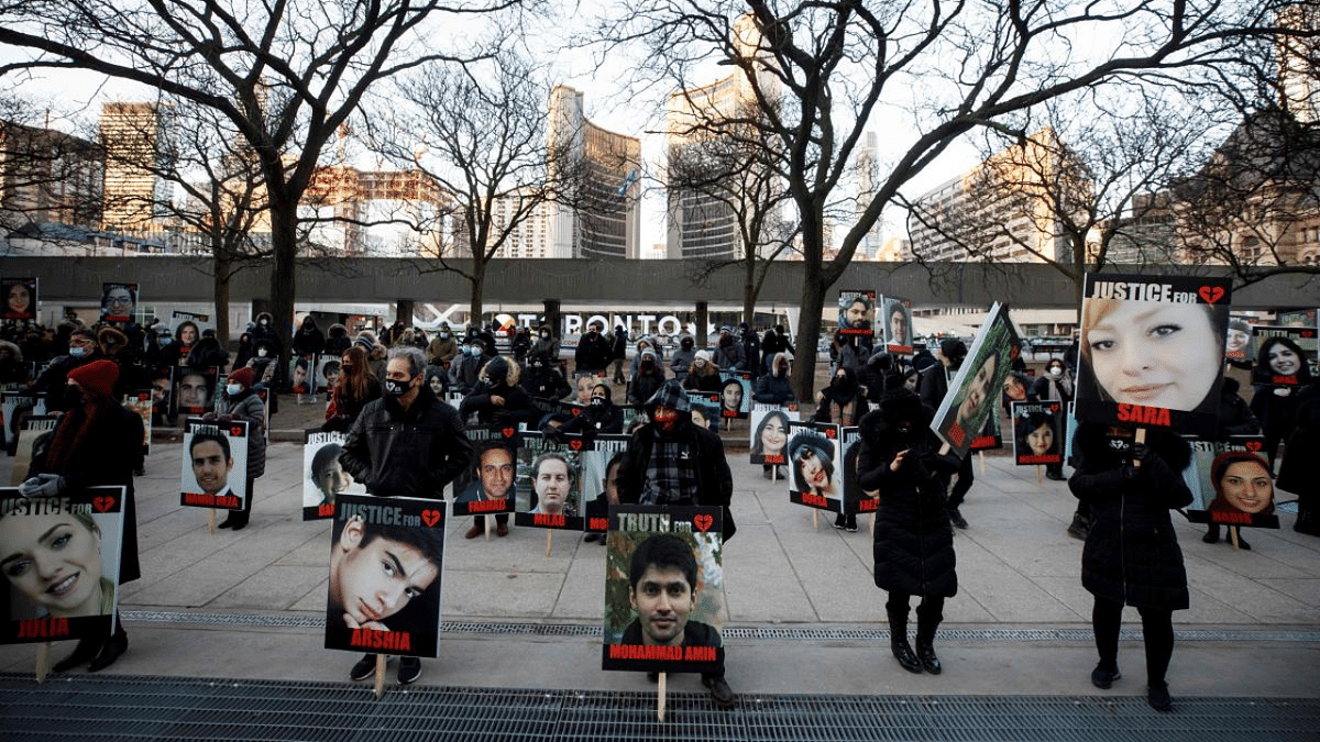 People hold signs with images of the victims of the downed Ukraine International Airlines flight PS752, which was shot down near Tehran by Iran's Revolutionary Guard, as family and friends gather to take part in a march to mark the first anniversary, in Toronto, Ontario, Canada. Credit: AFP Photo