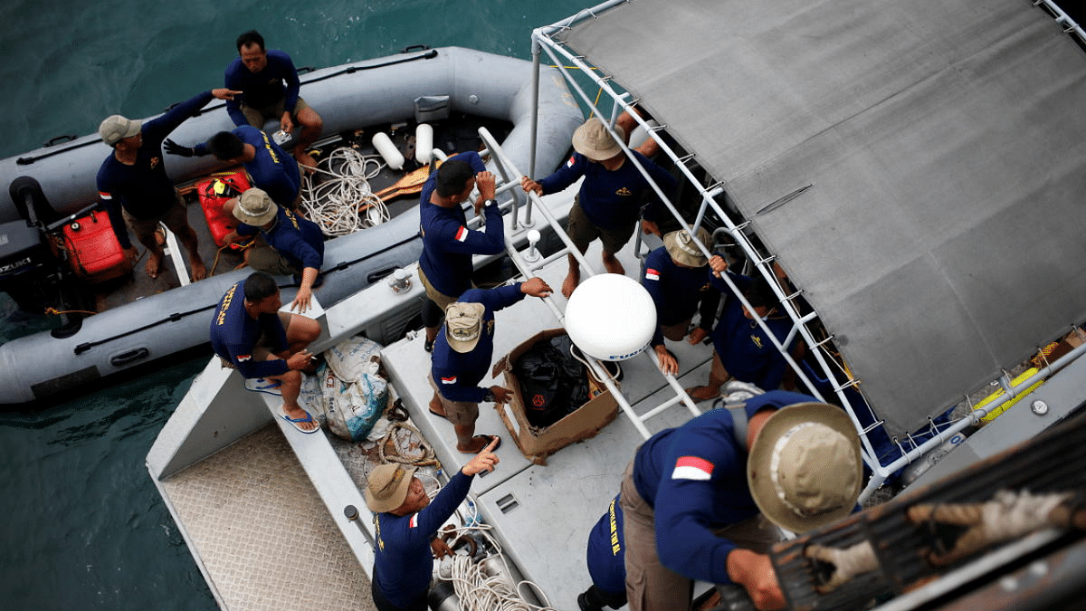 Indonesian navy divers are seen on a rubber boat and aboard the Indonesian Naval warship as they prepare to participate in the search and rescue operation for the Sriwijaya Air flight SJ 182, at the sea off the Jakarta coast, Indonesia. Credit: Reuters Photo