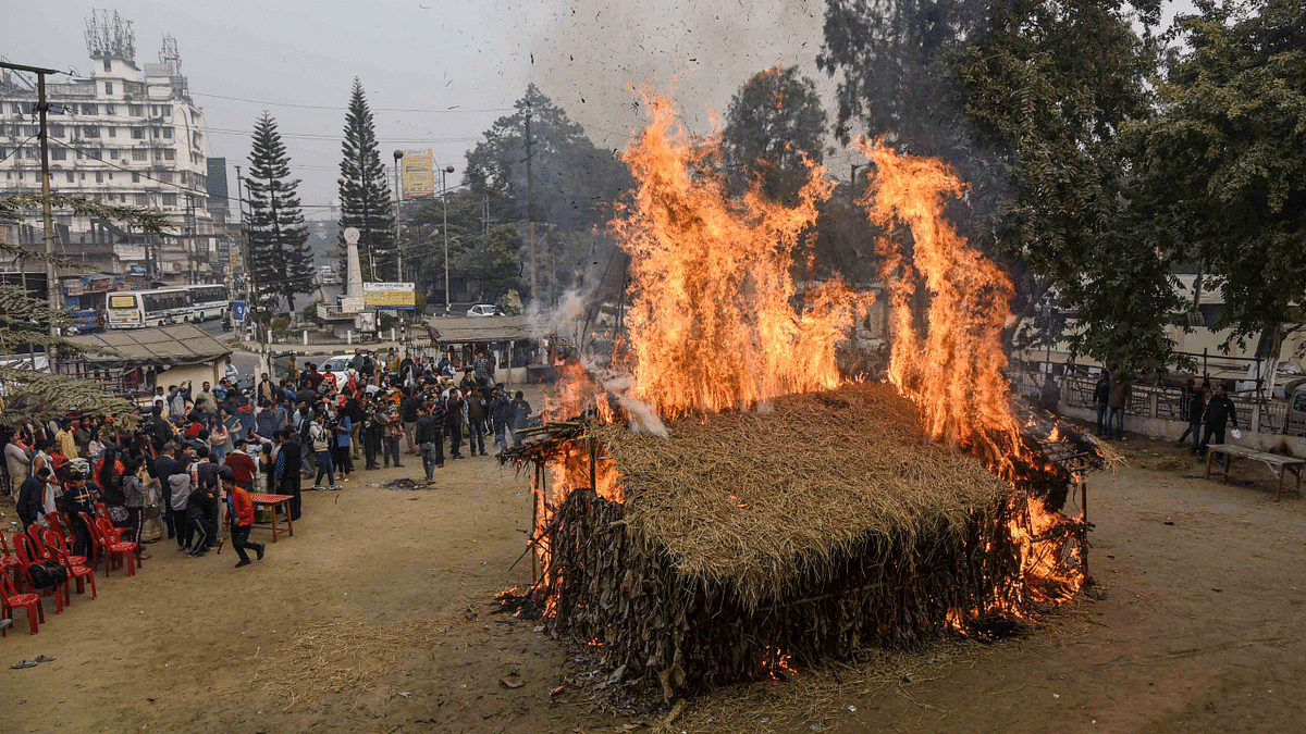 Traditional Assamese 'Meji', a house made of straw, being burnt during the Magh Bihu celebrations, at Ganeshguri in Guwahati. Credit: PTI Photo