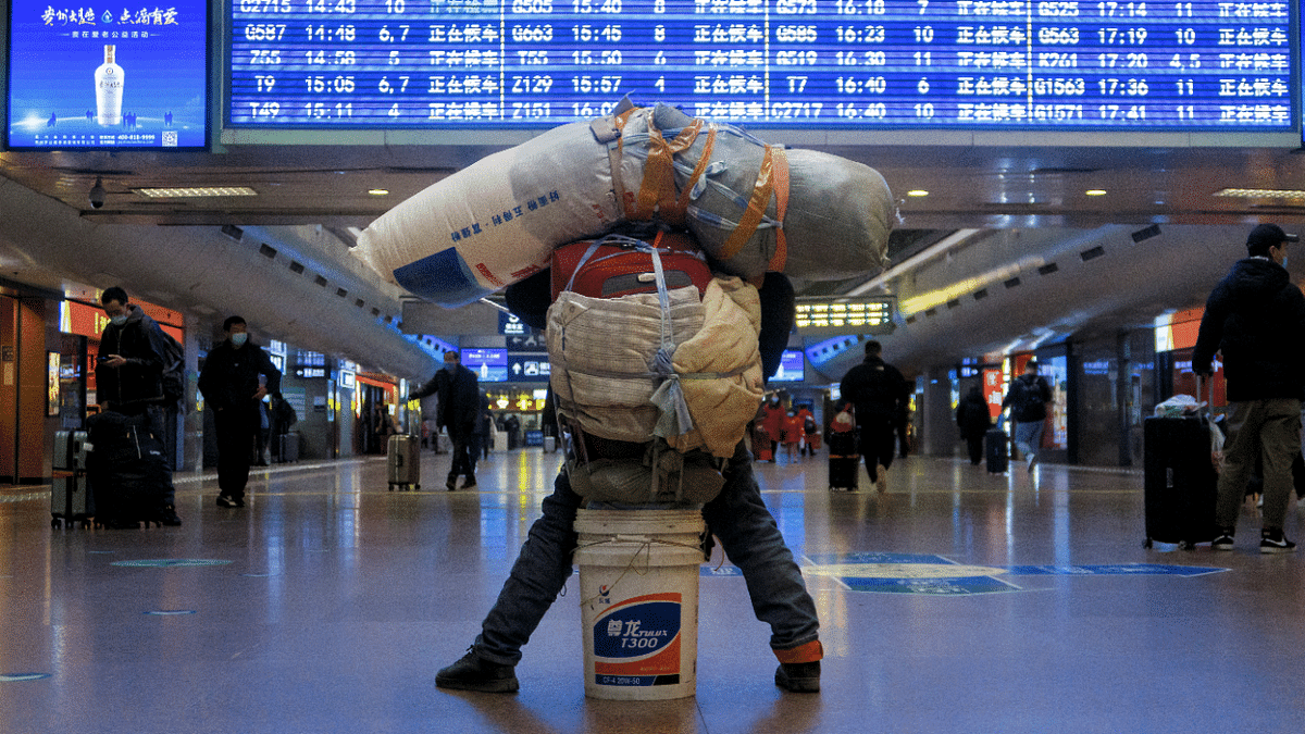 A traveller is seen with his belongings at a railway station, following the Covid-19 outbreak, in Beijing, China. Credit: Reuters Photo