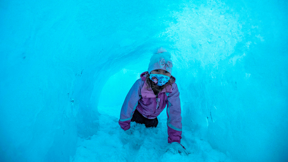 A child crawls through an ice tunnel as they explore the ice walls, tunnels and lights at Ice Castles in North Woodstock, New Hampshire, United States. Credit: AFP Photo