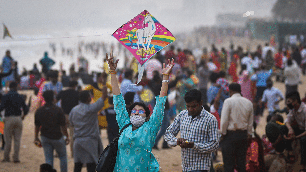 A woman attempts to fly a kite during her visit to RK Beach on 'Makar Sankranti' festival, in Visakhapatnam. Credit: PTI Photo