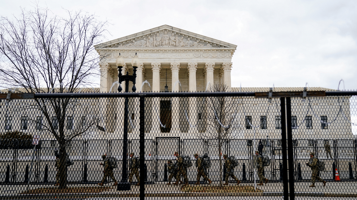 National Guard troops walk behind fencing in front of the US Supreme Court as security tightens ahead of presidential inaugural events on Capitol Hill in Washington, US. Credit: Reuters Photo