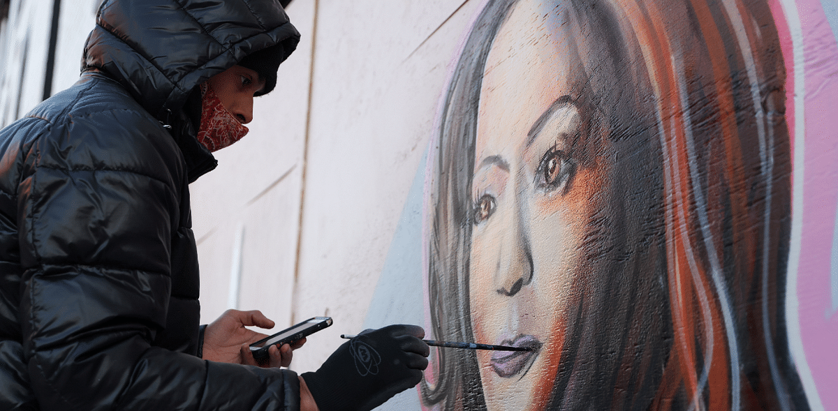 An artist from the nonprofit P.A.I.N.T.S. Institute, works on a mural of US Vice President-elect Kamala Harris on Martin Luther King Day in Washington, US. Credit: Reuters Photo
