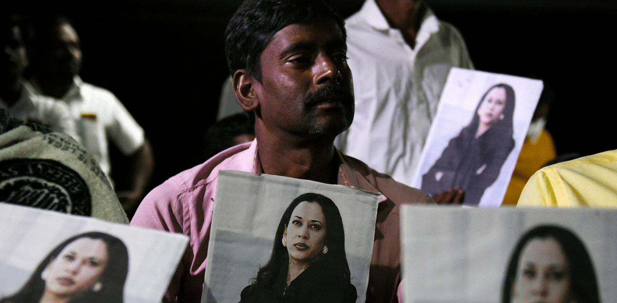 A resident holds pictures of US Democratic Vice President-Elect Kamala Harris as he attends a gathering to watch Kamala Harris inaugural ceremony at her ancestral village of Thulasendrapuram, in Tamil Nadu. Credit: AFP Photo