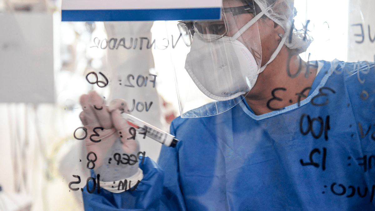 Health workers writes notes on a glass as she checks a Covid-19 patient at the Intensive Care Unit (ICU) at the Pablo Tobon Uribe Hospital, in Medellin, Colombia. Credit: AFP Photo
