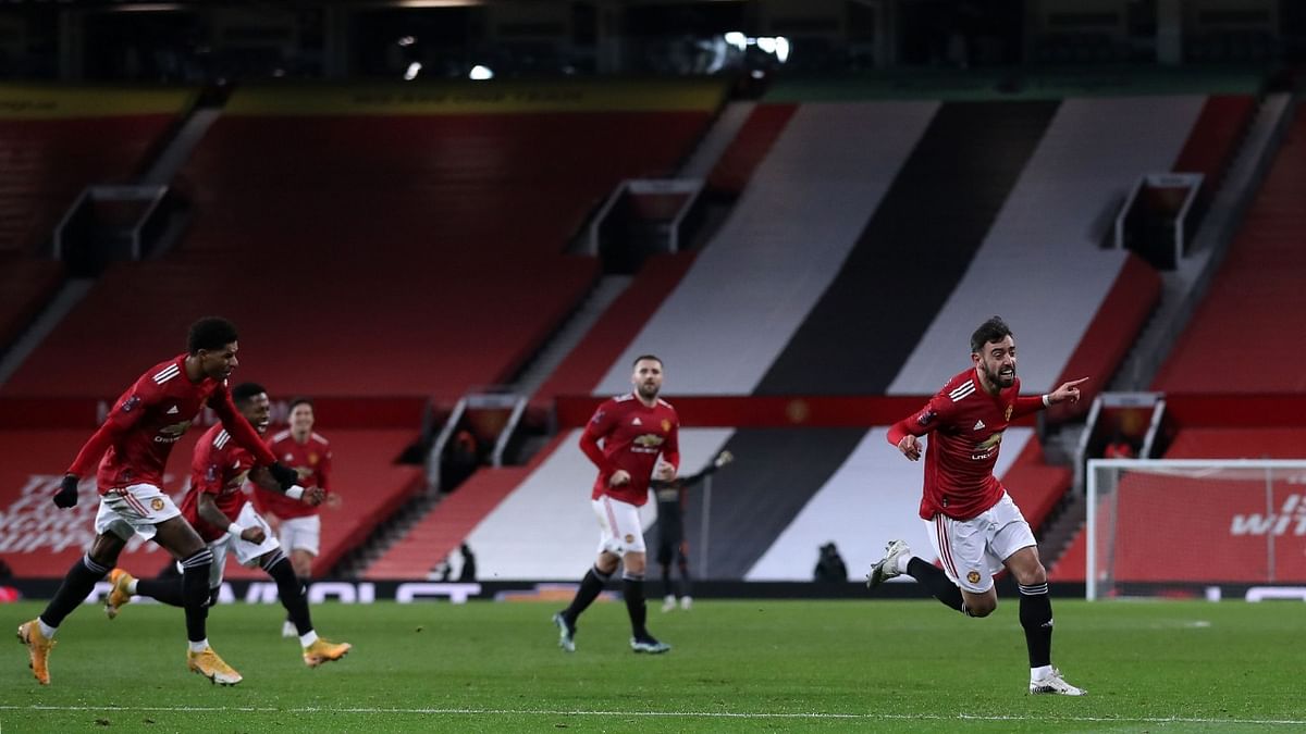 Manchester United's Portuguese midfielder Bruno Fernandes (R) celebrates scoring his team's third goal during the English FA Cup fourth round football match between Manchester United and Liverpool at Old Trafford in Manchester, north west England. Credit: AFP Photo.