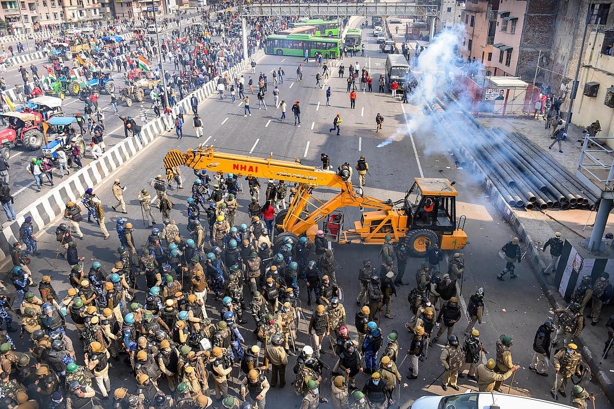 Police uses tear gas to disperse farmers attempting to break barricades at Ghazipur border during their 'Kisan Gantantra Parade'. Credit: PTI Photo