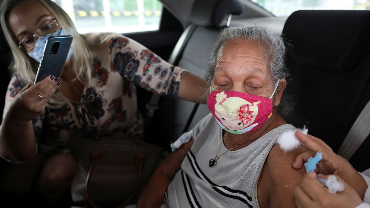 A woman receives the AstraZeneca/Oxford Covid-19 vaccine at a drive-thru vaccine station for seniors citizens aged 80 and above in Manaus, Brazil. Credit: Reuters Photo.