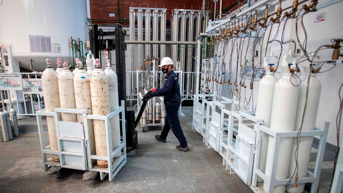 A worker moves oxygen cylinders to be used in intensive care units for Covid-19 patients in Bogota. Credit: AFP Photo.