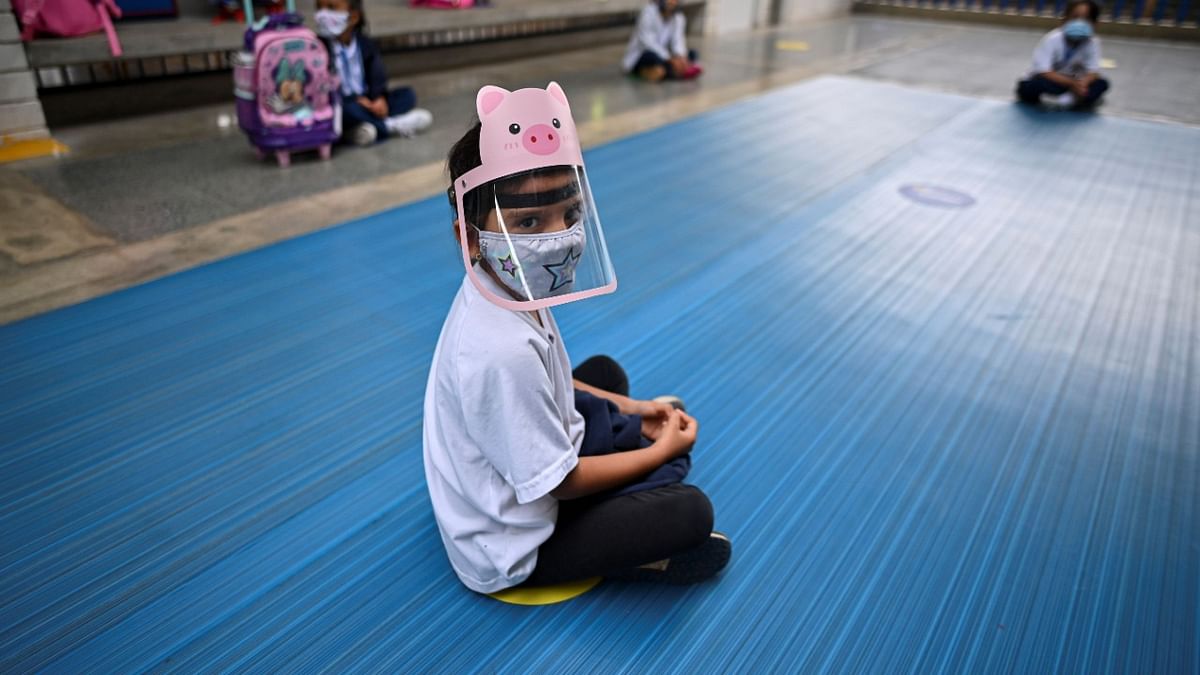A child wears a face mask and shield as a preventive measure against the spread of the Covid-19, at the Paul Valery French School in Yumbo, Valle del Cauca department, Colombia. Credit: AFP Photo.