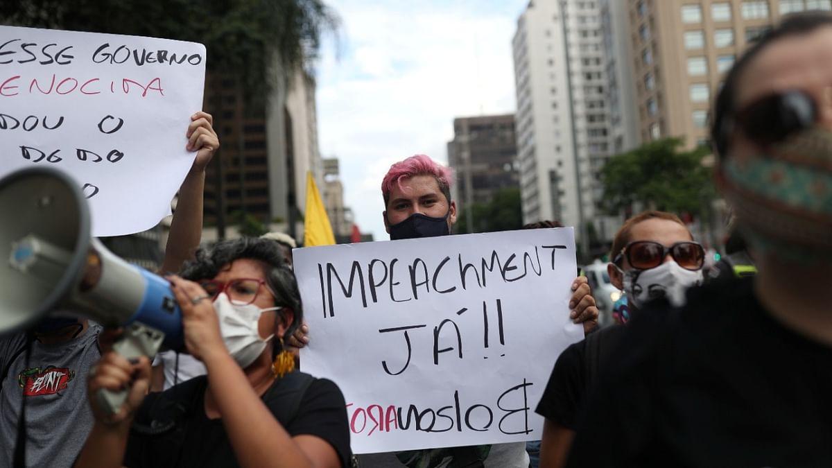 A demonstrator holds a placard reading ''Impeachment now, Bolsonaro out'' as they take part in a protest against Brazil's President Jair Bolsonaro and his handling of the Covid-19 outbreak, in Sao Paulo, Brazil. Credit: Reuters Photo