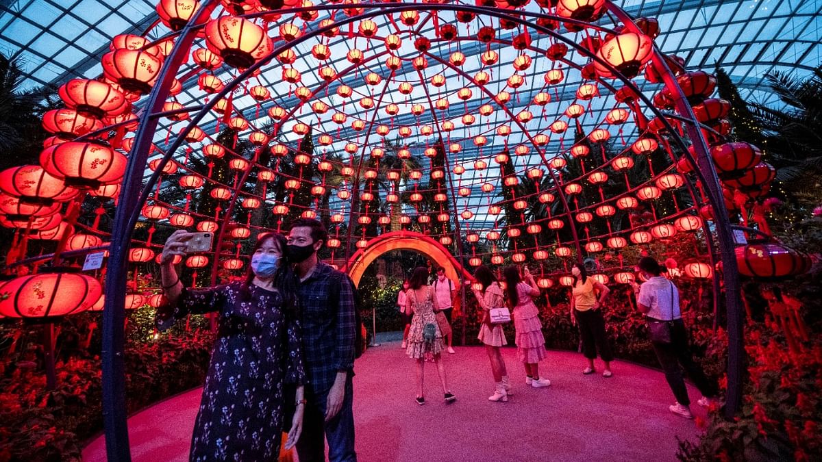 Visitors wearing face masks take pictures during the annual Dahlia Dreams floral display ahead of the Chinese Lunar New Year of the Ox, otherwise known as the Spring Festival, at Singapore's Gardens by the Bay. Credit: Reuters Photo