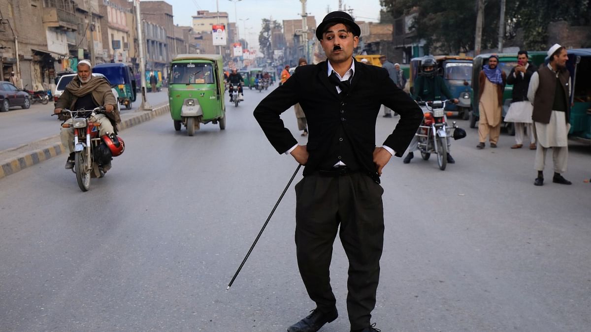 Usman Khan, 29, dressed up as Charlie Chaplin, performs along the street in Peshawar, Pakistan. Credit: Reuters Photo