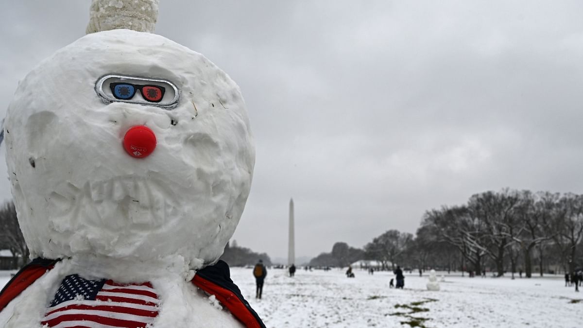 A masked snowman sits on the National Mall in Washington, DC not far from the US Capitol on January 31, 2021 as the capital region is under a winter storm warning through Monday night for an expected five or more inches (12.7 centimeters) of snow. Credit: AFP Photo