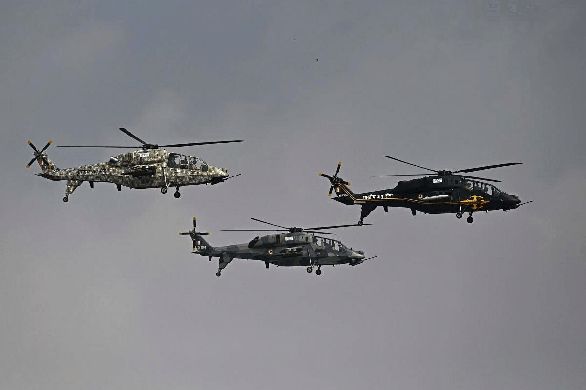 Indian Air Force (IAF) helicopters fly past during the first day of the Aero India 2021 Airshow. Credit: AFP Photo