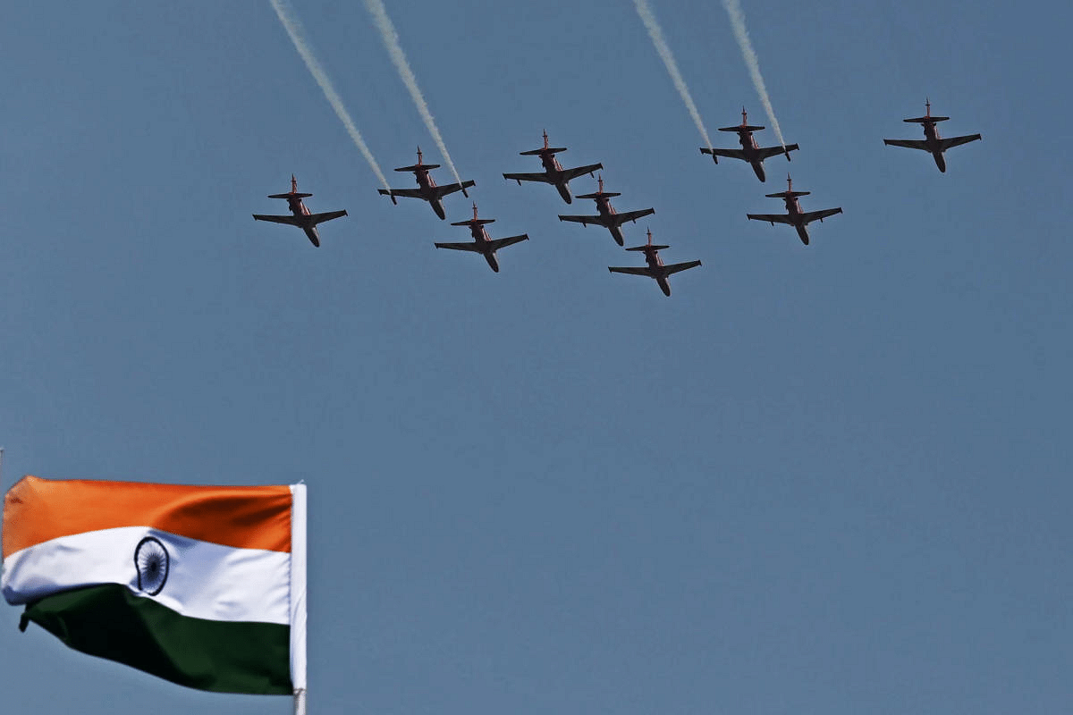 Indian Air Force’s acrobatic team ‘Surya Kiran’ flies past an Indian national flag during the first day of the Aero India 2021 Airshow. Credit: AFP Photo