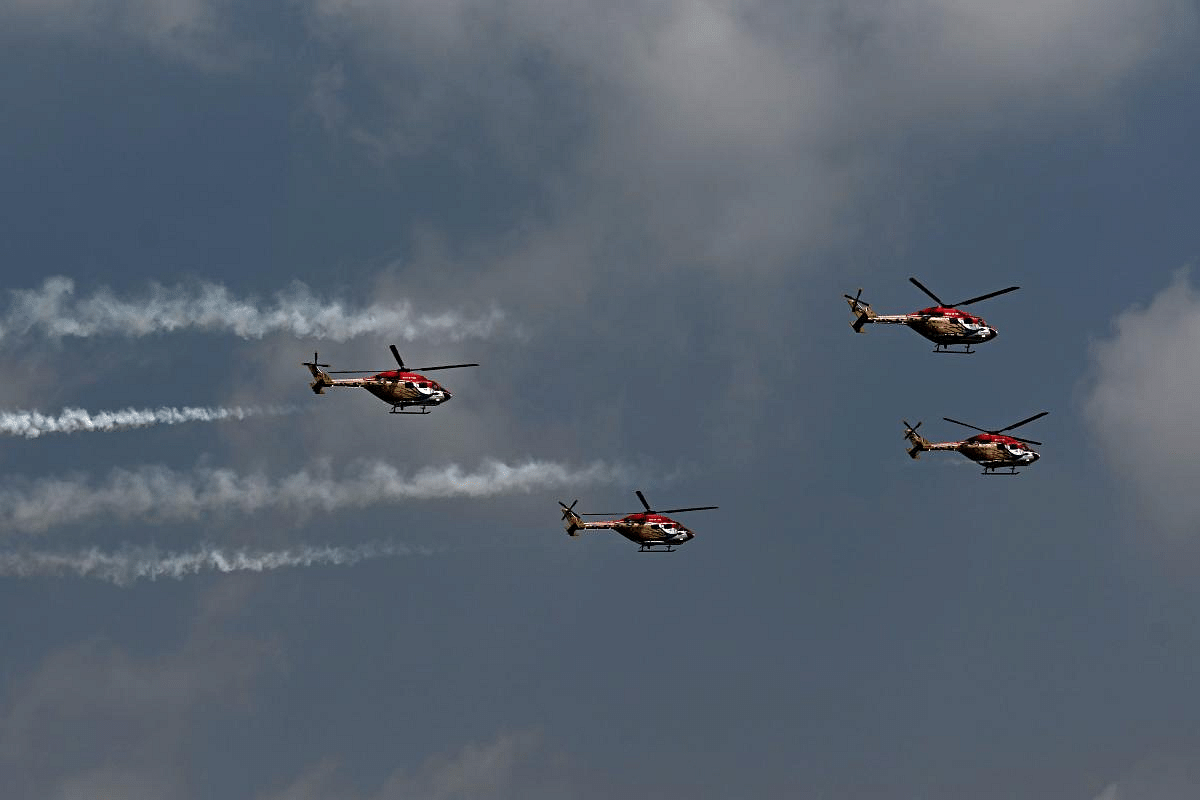 Indian Air Force's Advanced Light Helicopter (ALH) 'Sarang' acrobatic team performs during the first day of the Aero India 2021 Airshow. Credit: AFP Photo
