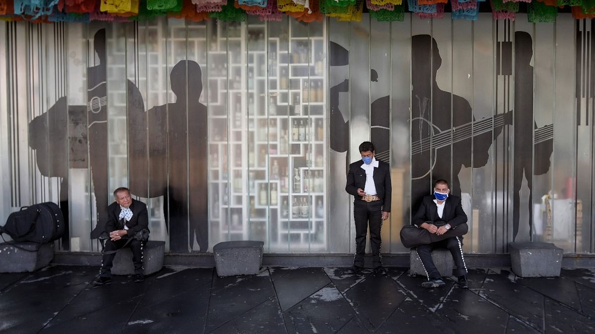 Mexican Mariachis (tradional musicians) wearing face masks wait for customers at Garibaldi Square in Mexico City. Credit: AFP Photo.