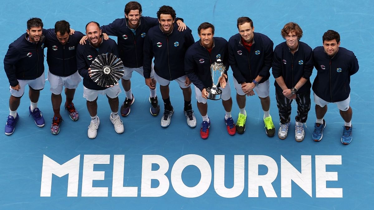 Team Russia (R) hold a winner's trophy as team Italy (L) hold a runners-up trophy at a ceremony of ATP Cup men's final in Melbourne on February 7, 2021. Credit: AFP Photo