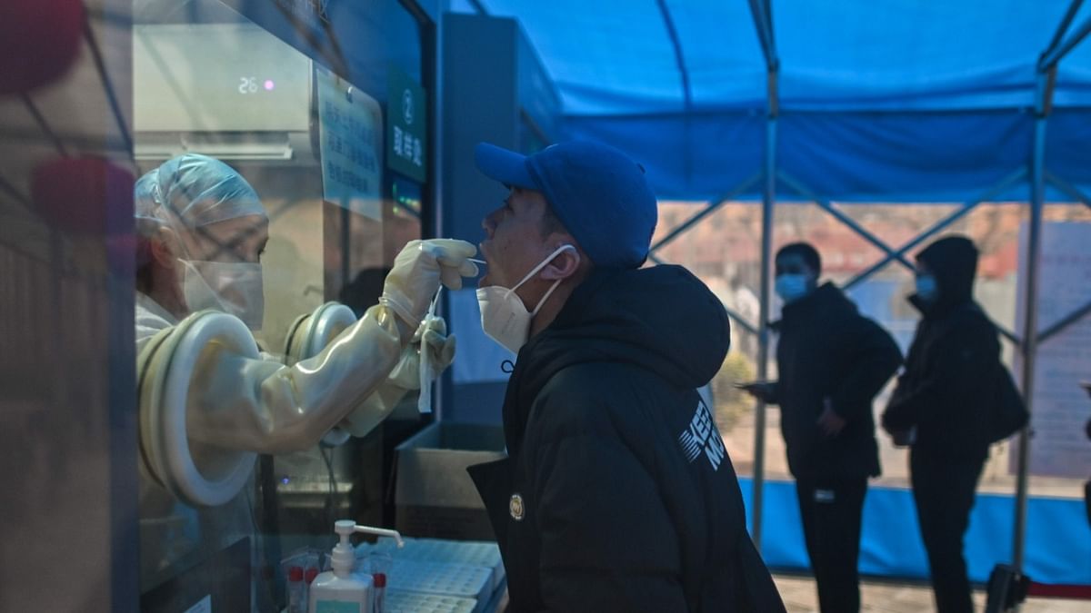 A health worker takes a swab sample from a man to test for the Covid-19 coronavirus at a hospital in Wuhan, China's central Hubei province on February 7, 2021. Credit: AFP Photo