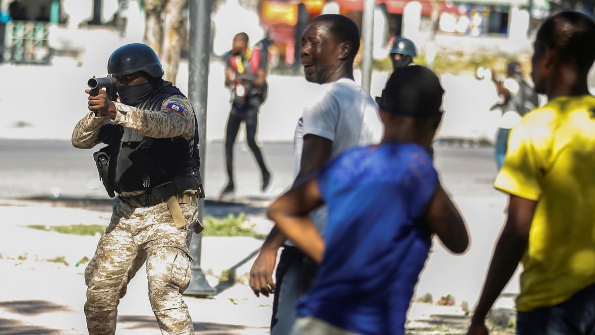 A police officer aims at demonstrators during protests against Haiti's President Jovenel Moise, in Port-au-Prince, Haiti. Credit: Reuters Photo.