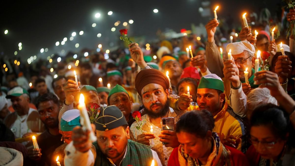 Farmers participate in a candlelight vigil to pay homage to paramilitary troops killed in a suicide bomb attack in south Kashmir's Pulwama district in 2019, at the site of a protest against new farm laws at the Delhi-Uttar Pradesh border in Ghaziabad, India. Credit: Reuters Photo.