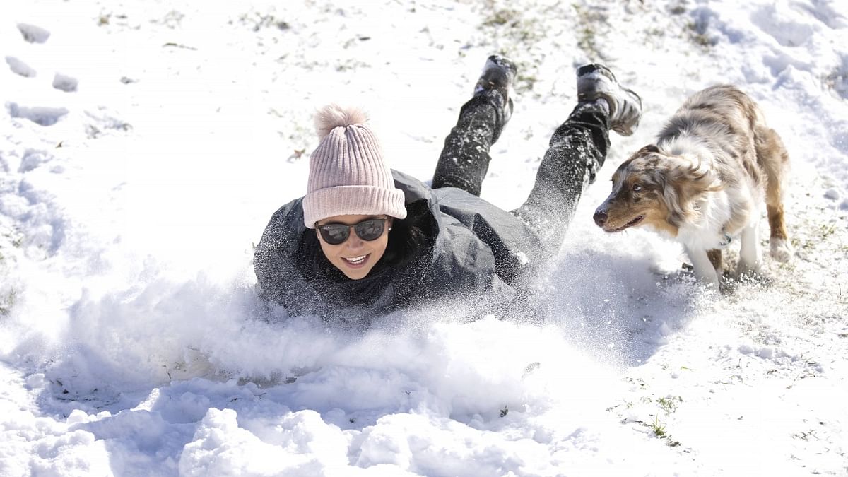 Megan Pennartz and her dog Jensen go sledding after a snow storm in Fort Worth, Texas. Credit: AFP Photo