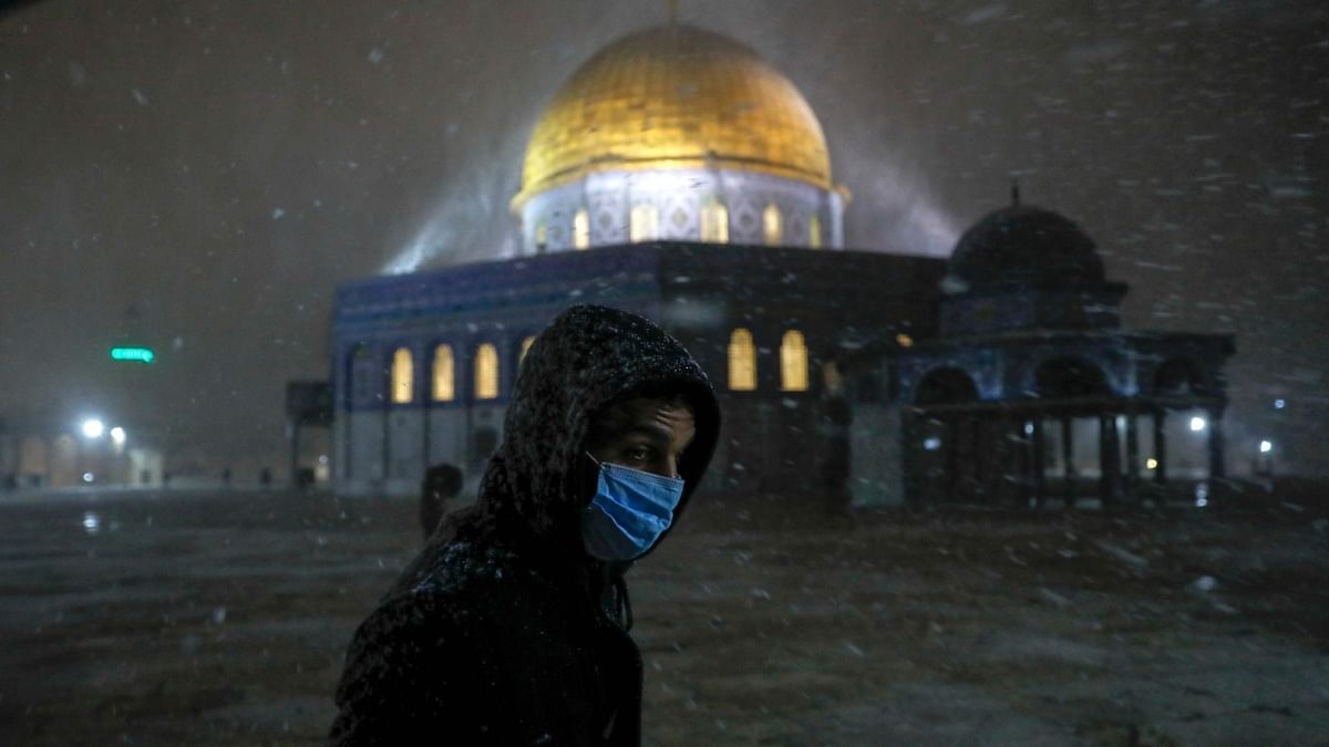 A Palestinian worshiper walks as snow falls at the Dome of the Rock Mosque in Jerusalem's al-Aqsa mosque compound. Credit: AFP Photo