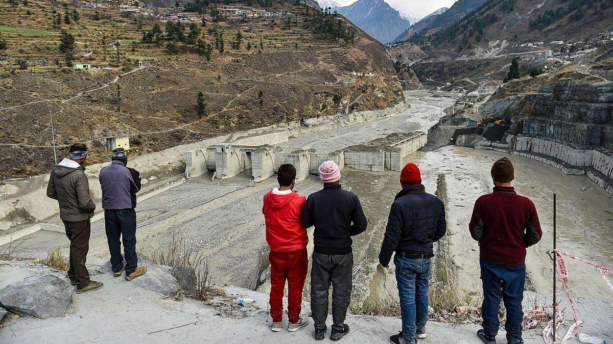 People watch the rescue and restoration work at damaged Tapovan barrage, weeks after the glacier burst at Joshimath which triggered a massive flash flood on Feb. 7, in Chamoli district of Uttarakhand. Credit: PTI Photo