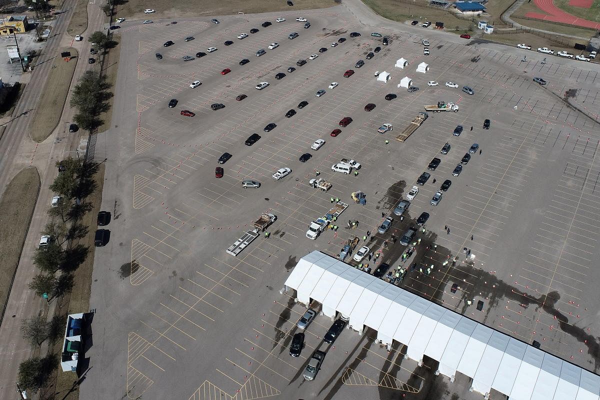 Cars line up to receive free cases of water after the city of Houston implemented a boil water advisory following an unprecedented winter storm, in an aerial photograph taken at Delmar Stadium in Houston, Texas. Credit: Reuters photo.