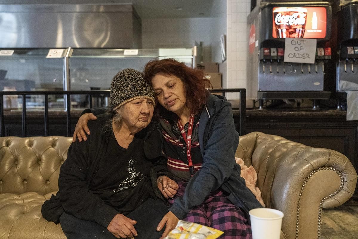 Deloris Sanchez, 56, and Mallissa Lee, 52, sit on a couch while taking shelters at Gallery Furniture store which opened its door and transformed into a warming station after winter weather caused electricity blackouts. Credit: AFP photo.