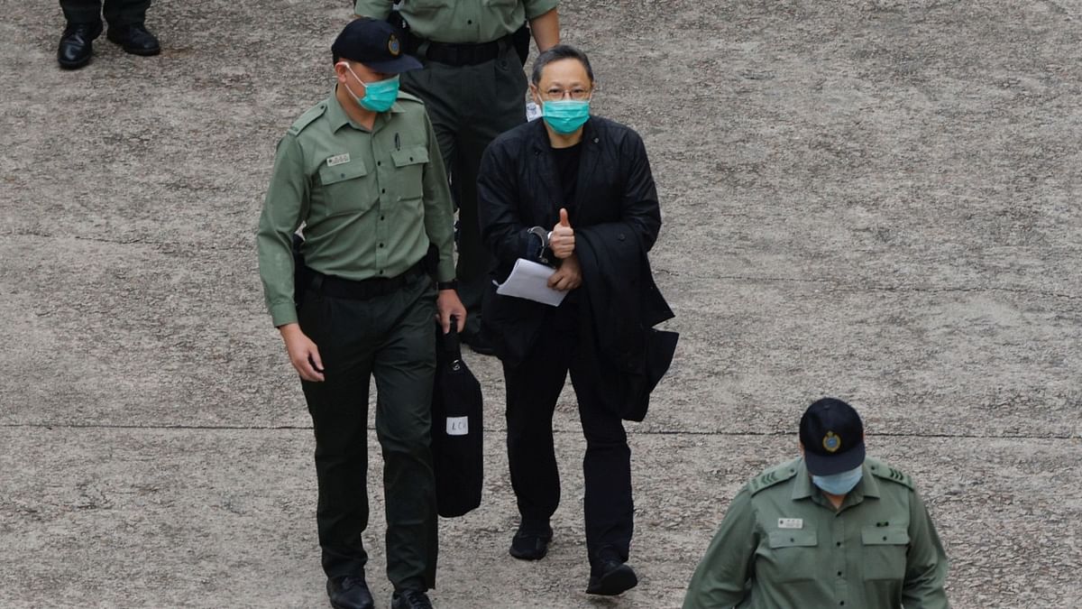 Pro-democracy activist Benny Tai flashes thumbs up as he walks to a prison van to head to court, over the national security law charge, in the early morning, in Hong Kong, China. Credit: Reuters Photo