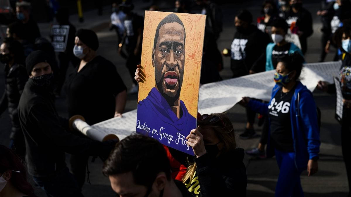 Demonstrators carry a scroll listing the names of people killed by police during a march in honor of George Floyd. Credit: AFP Photo