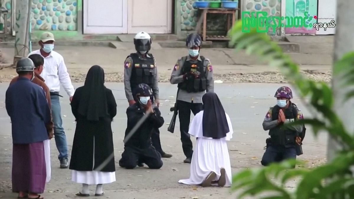 Myanmar nun Sister Ann Rose Nu Tawng kneels in front of police officers to ask security forces to refrain from violence against children and residents amid anti-coup protests in Myitkyina, Myanmar. Credit: Mytykina News Journal via Reuters Photo.