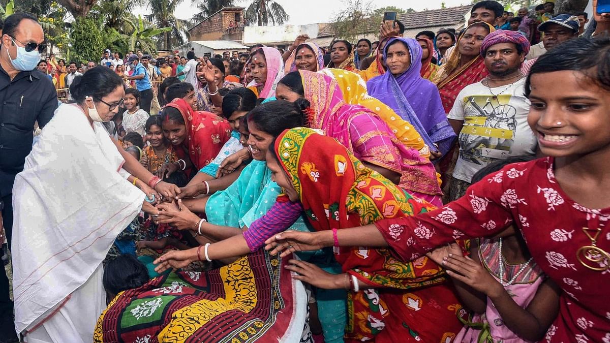 Women at fall at the feet of West Bengal Chief Minister Mamata Banerjee during an election campaign at Nandigram. Credit: PTI Photo.