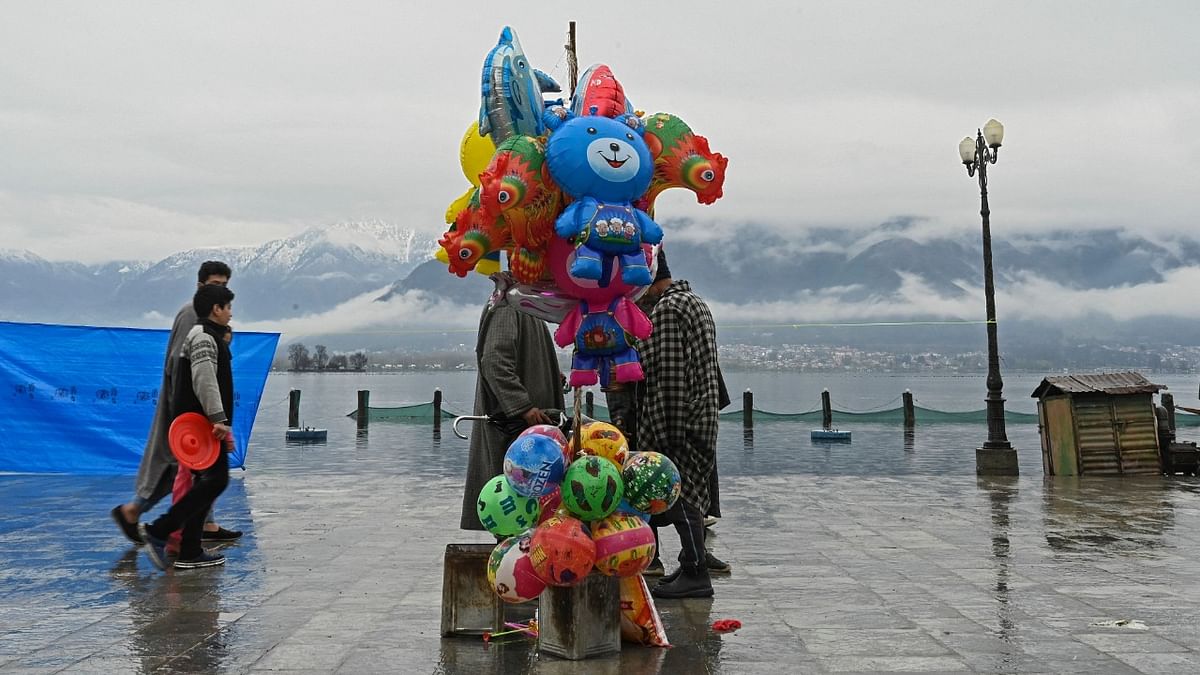 A roadside vendor selling toys and balloons talk to customers during near Kashmir's main Hazratbal shrine in Srinagar. Credit: AFP Photo