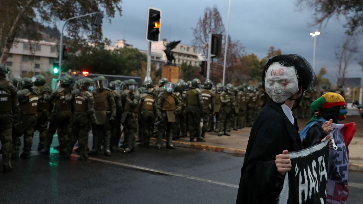 A demonstrator wears mask reading 'No More' in front riot police officers during a protest against Chile's government in Santiago, Chile. Credit: Reuters Poto