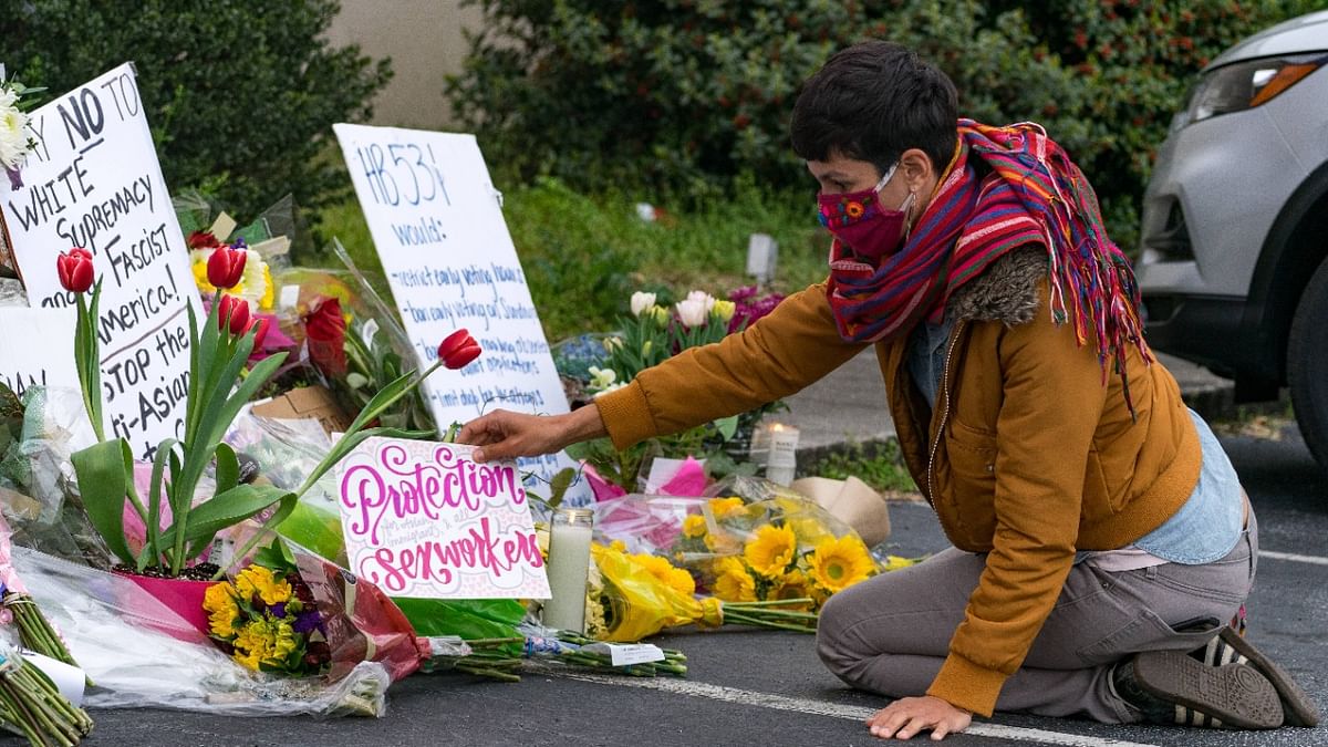 People bring flowers to the memorial sight set up outside of The Gold Spa in Atlanta, Georgia. Mourners have gathered across the United States to pay respect to the Asian community after suspect Robert Aaron Long, 21, attacked three spas killing eight people, six of whom were Asian. Credit: AFP Photo
